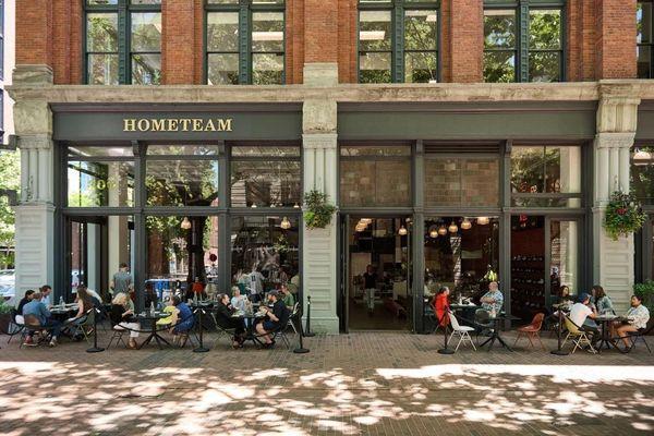 The inviting storefront of HOMETEAM SEATTLE, a premier sneaker store with limited edition sneakers and an indoor restaurant.