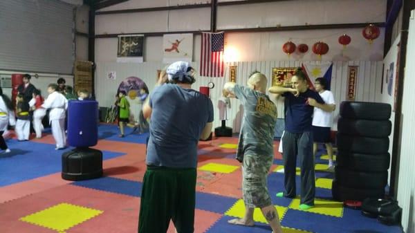 Adult MMA class practicing boxing techniques.