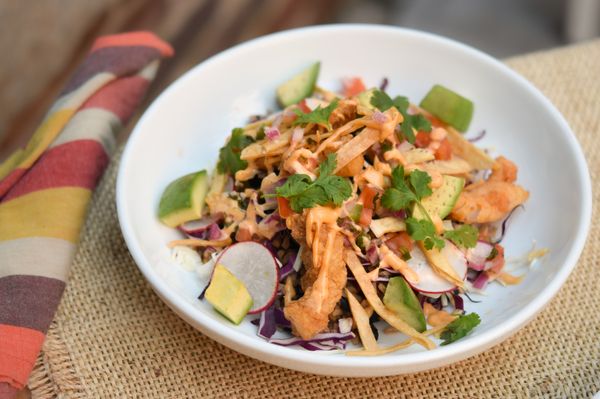 Baja Crispy Fish Bowl with rice, beans, cabbage, avocado, pico de gallo, radish, cilantro & drizzle of chipotle aioli & corn tortilla strips