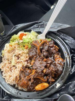 Yummy oxtail meal with rice and peas and steamed vegetables