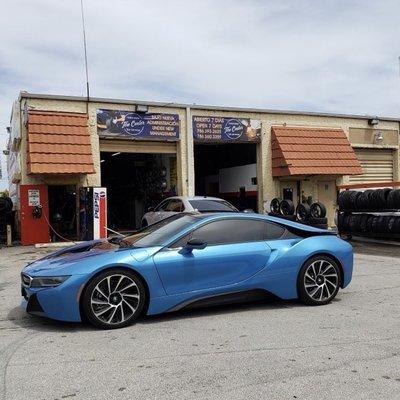 Happy customer showing off new tires in front of our shop