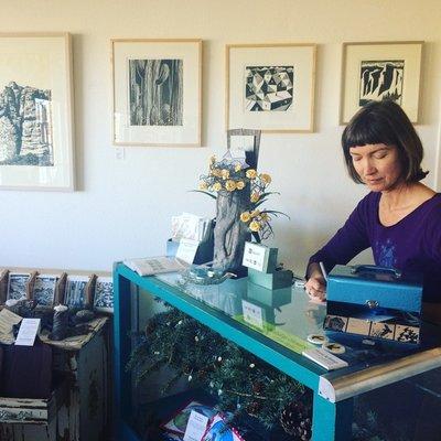 Owner/artist Rosie Carter with her father Thayer Carter's woodcut prints.