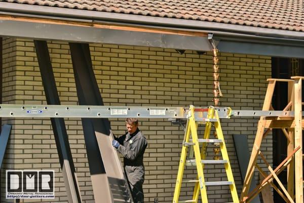 This shows our custom rain-cups outlet under an expansion joint needed for gutter jobs. This is at the Reedwood Friends Church