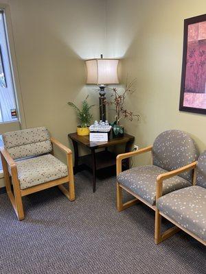 Our waiting room, with chairs, plants, and complementary bottled water.