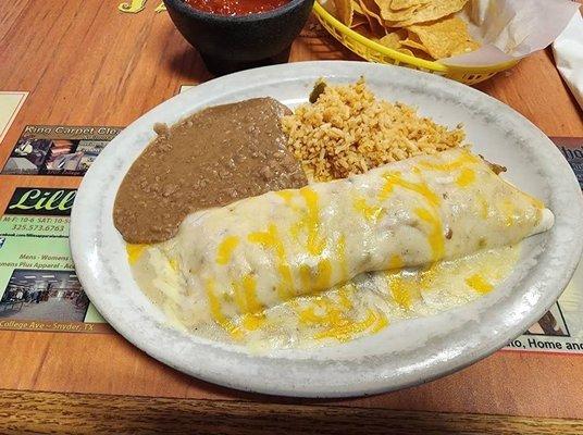 Chicken fajita burrito covered in green sauce and cheese