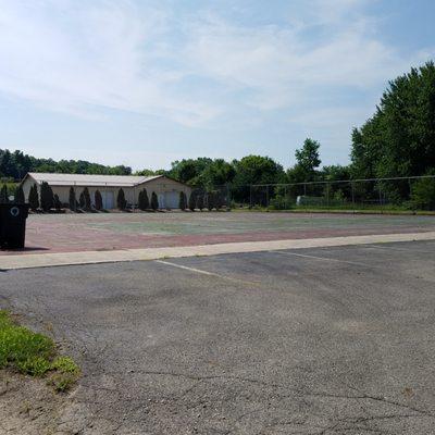 former tennis courts with the posts for holding the net removed