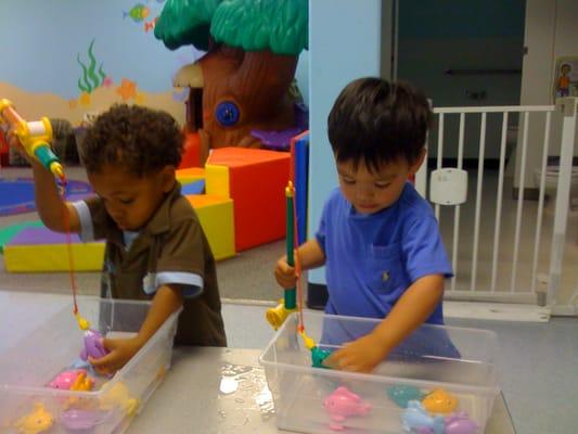 Toddlers at "work" developing small motor skills and socialization.