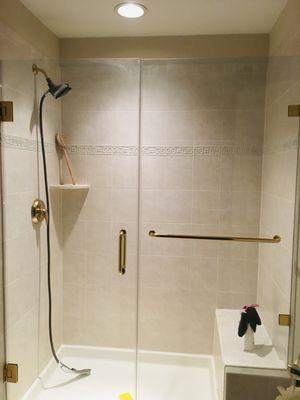 Shower wall tiles, standing shower base, shower bench with glass door installation