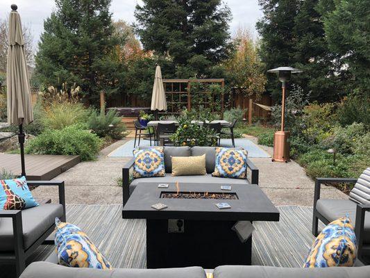 A fire pit, space heaters and umbrellas provide the ultimate in outdoor comfort in this naturalistic Palo Alto back yard.