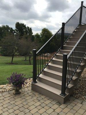 Deck stairs leading onto custom pavers.