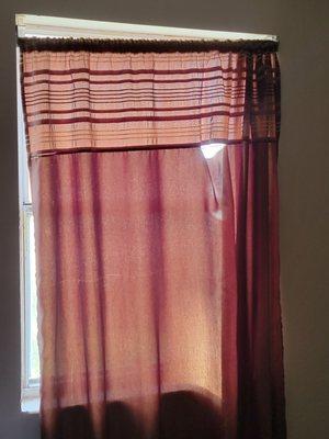 Torn curtains in bedroom