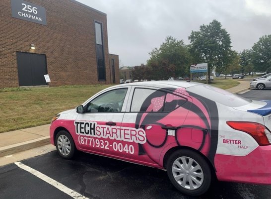 Techstarters pink and blue car outside of their location in Newark, Delaware