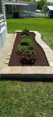 Spring of 2024 We redid a flower bed and added a retaining wall style edging around the flower bed, trimmed, planted, and added new plants.