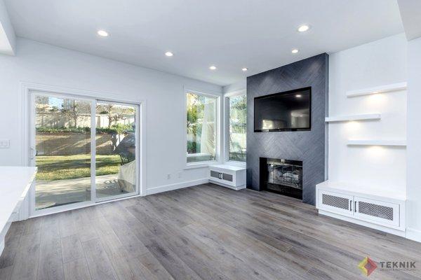 New fireplace, flooring, built-ins, inset TV framing, lighting, raised ceiling, and under-shelving lights!