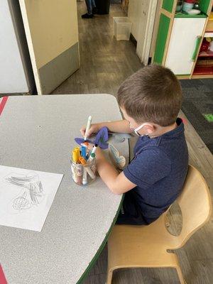 My son, coloring butterflies.