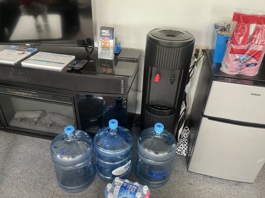 Three empty jugs of water in empty machine and the water I had to purchase