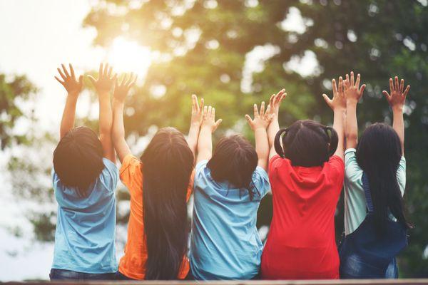 a group of kids reach for the sky in the outdoors at MC-CDC