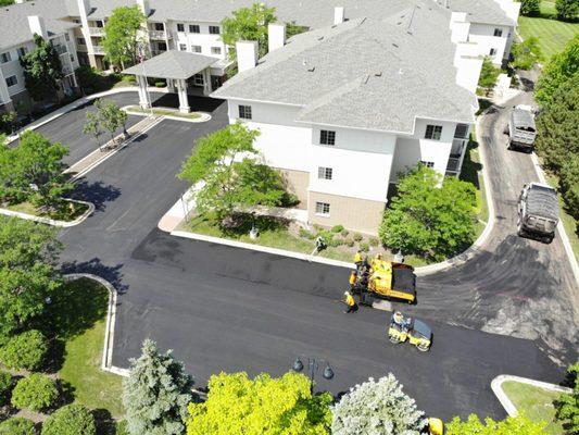 Housing complex with asphalt paving resurfacing in progress.