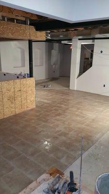 Ceramic tile floor wit 12 x 24 inch tiles in front of bar