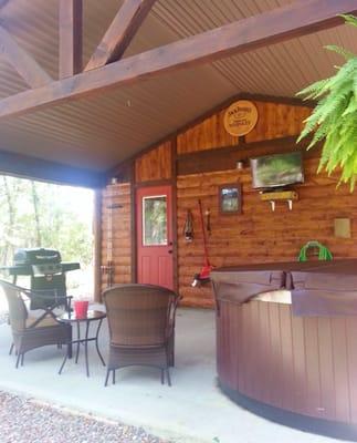 Back deck. Features flat screen TV,  jacuzzi hot tub, hammock, and fishing poles.