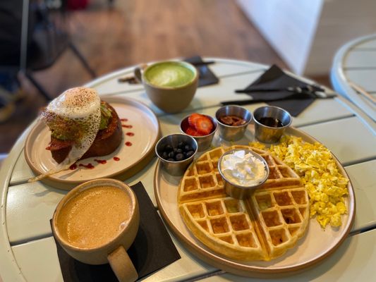 Loaded Avocado Toast , Belgium Waffles and scrambled eggs with toppings on the side. Matcha Latte and Cappuccino.