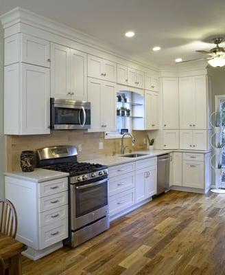 Transitional white painted cabinetry with wood backsplash.