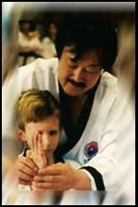 Grandmaster Duk San:  Sung H. Kim helping a student make a knife hand.