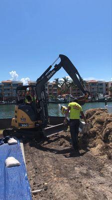 Using an excavator to haul a concrete column.