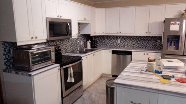 New cabinets countertops and glass backsplash