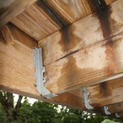 These deck joist hangers have missing nails, possibly causing a collapse.