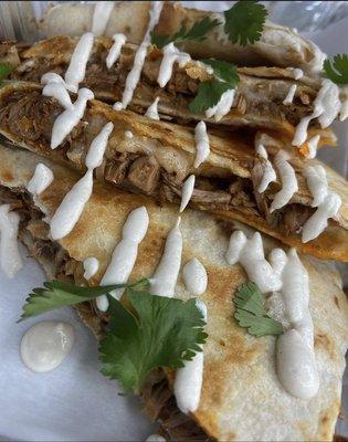 Jackfruit  and vegan cheese Quesadilla garnished with dairy free sour cream (optional) and fresh cilantro.