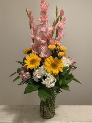 Gladiolus, Spray Roses, Sunflowers, Hydrangeas, Alstromeria, and Salal in a glass vase.