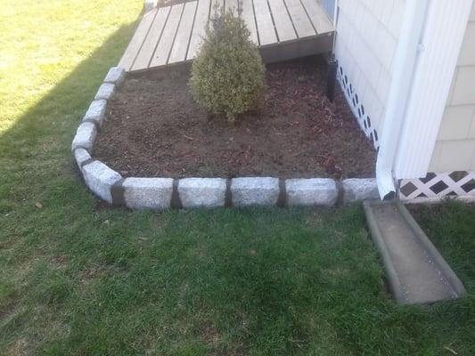 new Belgium block border with cement joints installed around mulch bed.