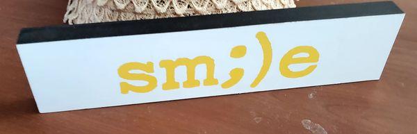 A cute little smile sign. It says, "sm;)e"