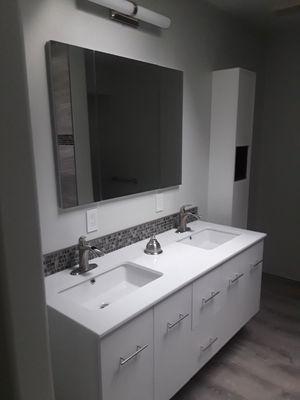 Wall mounted vanity with waterfall style faucets and solid surface vanity sink combo, recessed medicine cabinet/ mirror combo.