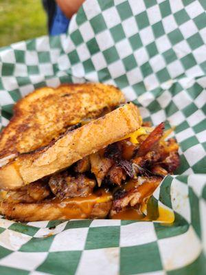 Amazing turkey leg sandwich with sautéed onions and peppers, a mustard style bbq sauce, and American cheese