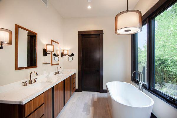 The ultimate owner's suite bathroom with a large window looking out to a private garden. All you need is the bath salts!