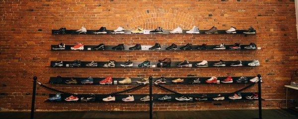 Display of exclusive sneakers at HOMETEAM SEATTLE, secured behind a museum-style barrier.