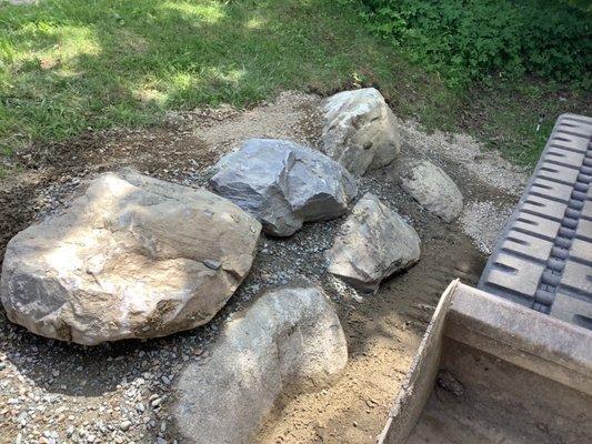 The smaller retaining wall made with native Maine boulders