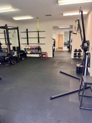 Main workout space with kettlebells, Keiser functional machine, TRX, and leg press.