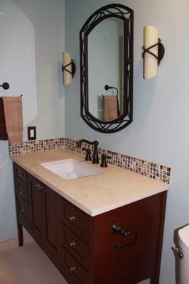 Bathroom remodel project vanity with metal framed mirror and sconce light