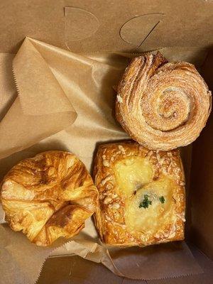 Kouign Amann (bottom left), savory croissant (bottom right with cheese) and morning buns on top. All highly recommended!!