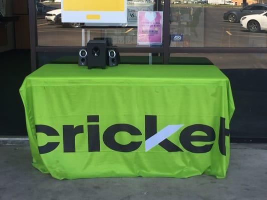 Lonely table outside blasting music while two employees are inside with no customers.