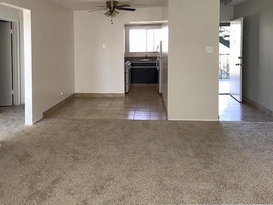 Living room view of tiled dining area and front entry