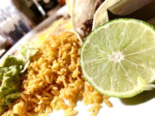 Lime, guacamole, rice, carne asada tacos