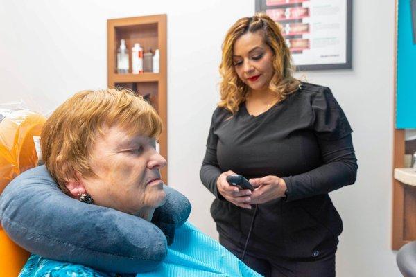 Patient with neck pillow and massage chair during treatment at Harwood Smiles