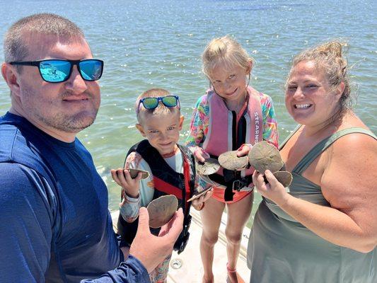 Happy family about to release the live sand dollars they found