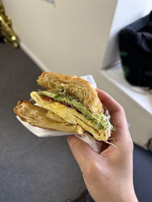 Breakfast croissant with bacon, add avocado and sprouts