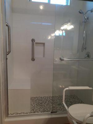 Large white tile with ADA bench and grab bars. Shower  remodel