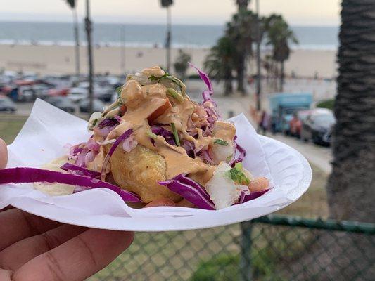 One fish beer battered taco with colorful cabbage!